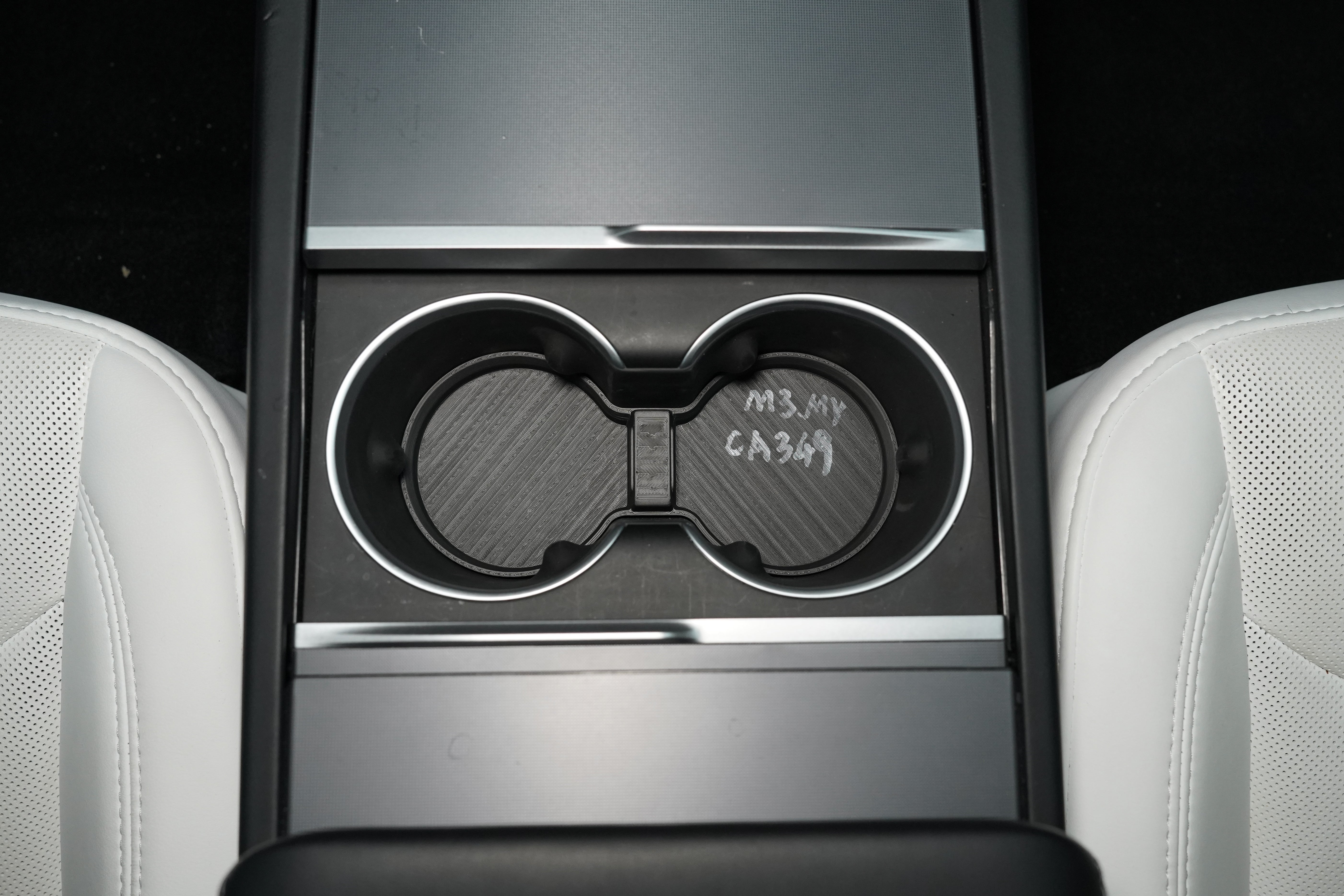 BASENOR TPE cup holder insert installed in the twin cup holders of a 2024+ Tesla Model 3 Highland