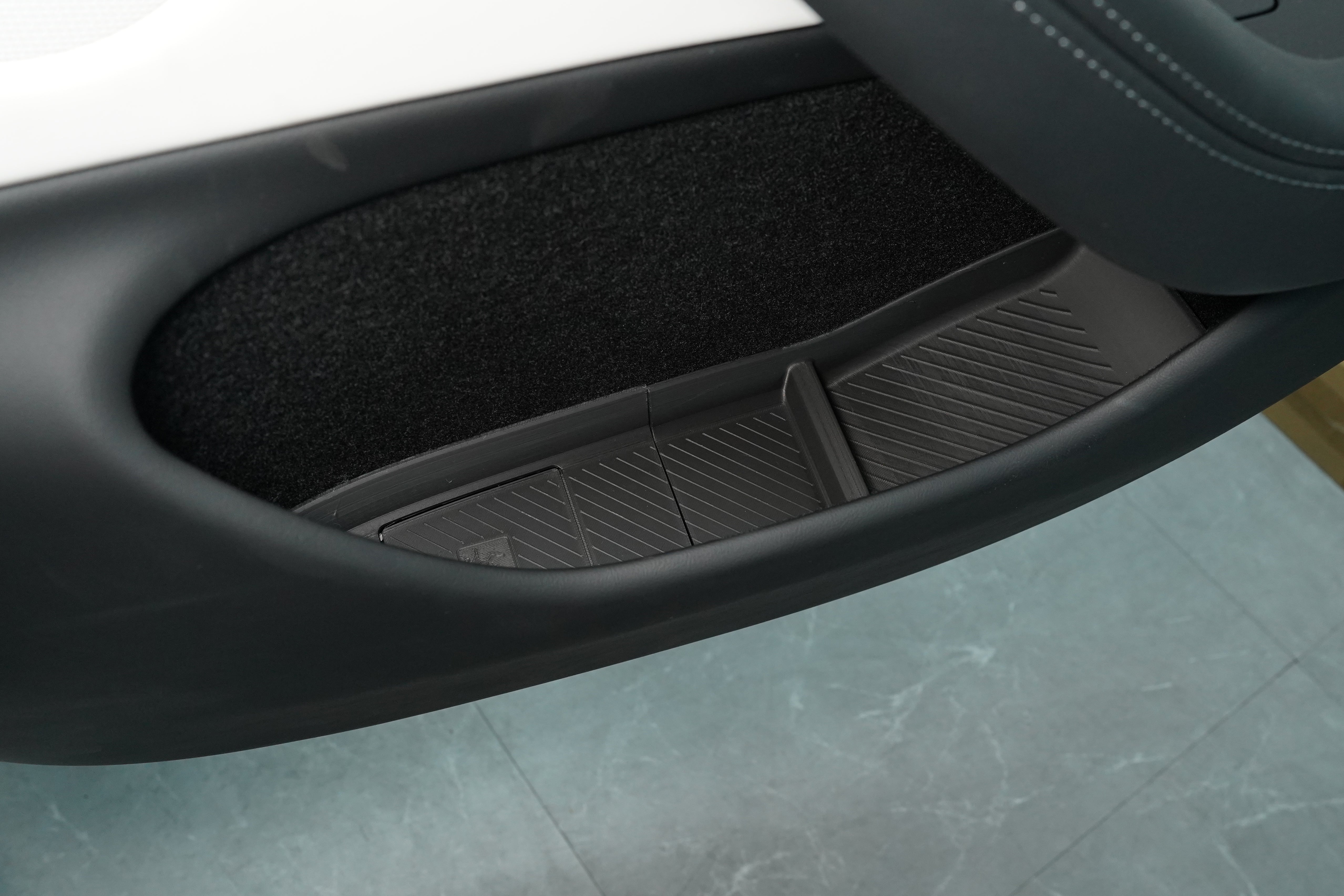 BASENOR TPE door pocket insert installed on a 2025+ Tesla Model Y Juniper front door, integrated flush with the factory armrest and door card