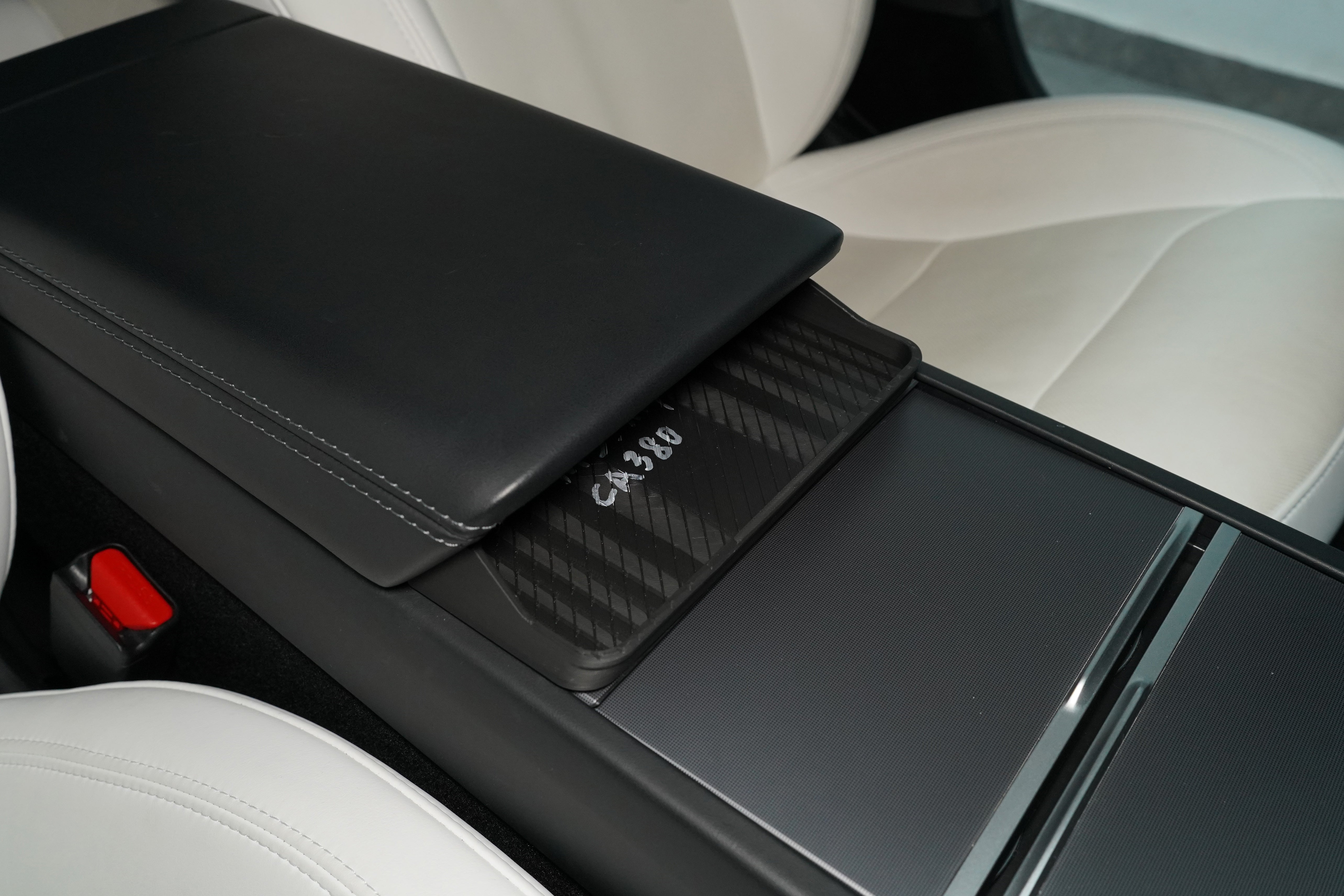 BASENOR sunglasses holder installed in the armrest cavity of a 2024+ Tesla Model 3 Highland with white leather interior